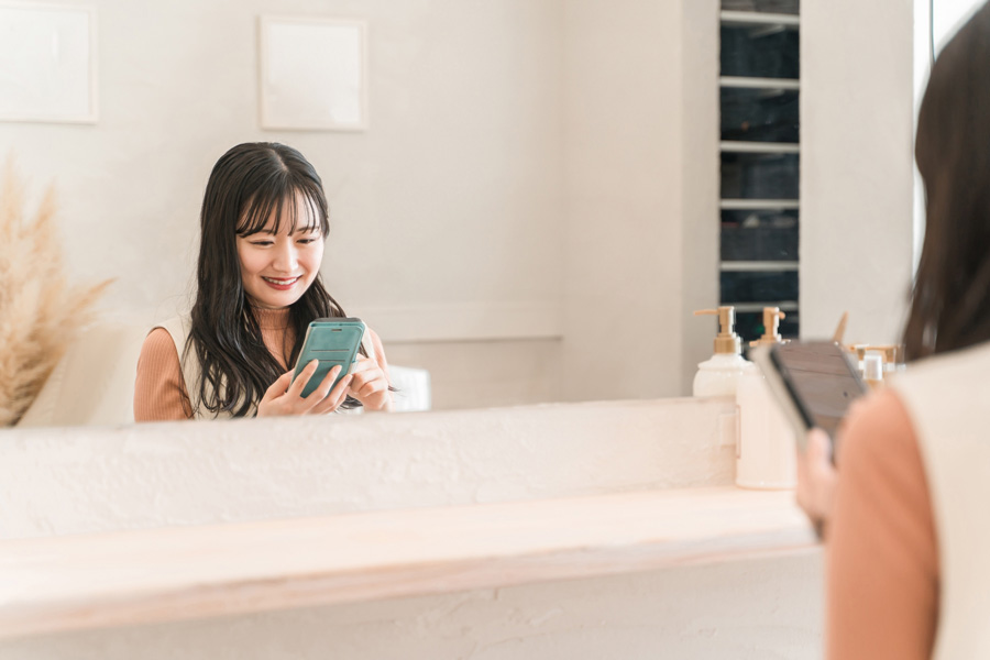 美容室でスマホを見る女性